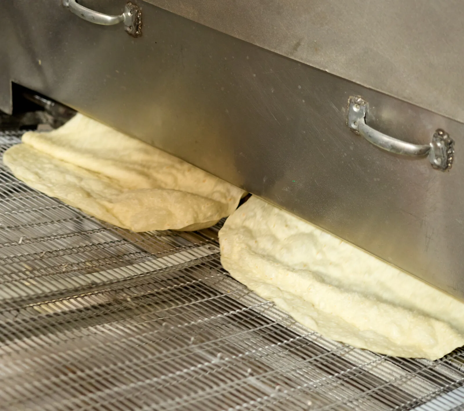 Tortillas saliendo de la línea a la banda de malla